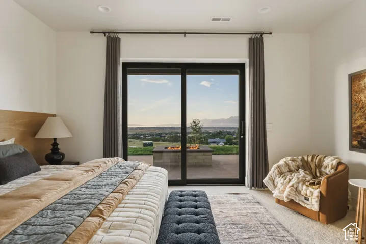Spacious room featuring a sliding glass door, a private patio, and a built-in fire pit