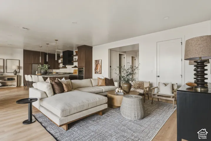 Open-concept living space featuring wood-finish flooring, recessed lighting, and a white interior door
