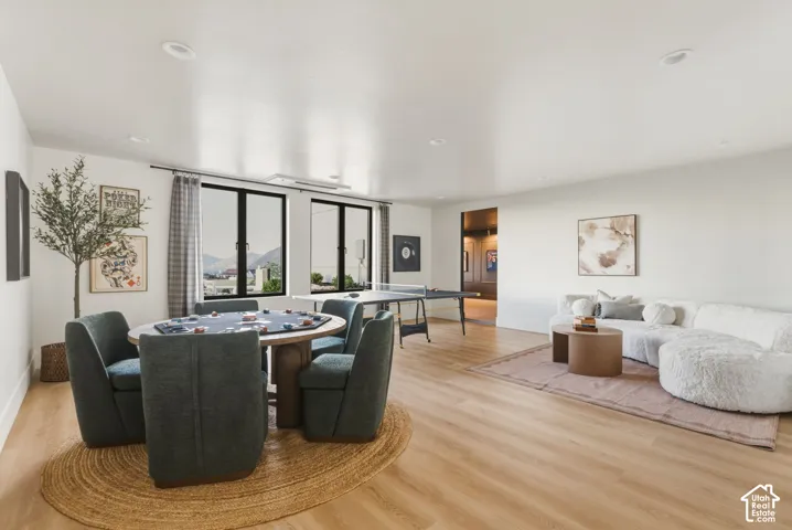 Spacious room featuring light wood-finish flooring, recessed lighting, and white walls