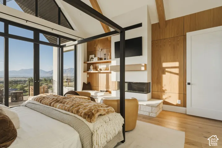 Vaulted ceilings with exposed beams complement expansive windows, offering panoramic outdoor scenery