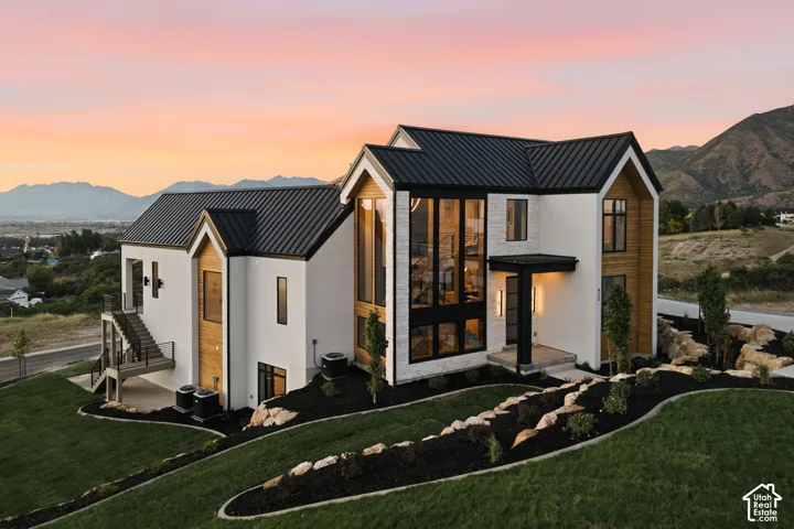 Contemporary exterior architecture featuring a white facade, wood-finish accents, and a black metal roof