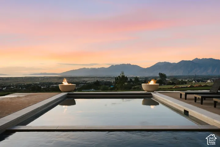 Outdoor pool area featuring a rectangular pool with integrated fire bowls