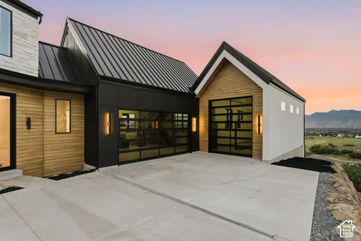 Modern architectural design featuring vertical wood siding, dark metal accents, and a corrugated metal roof