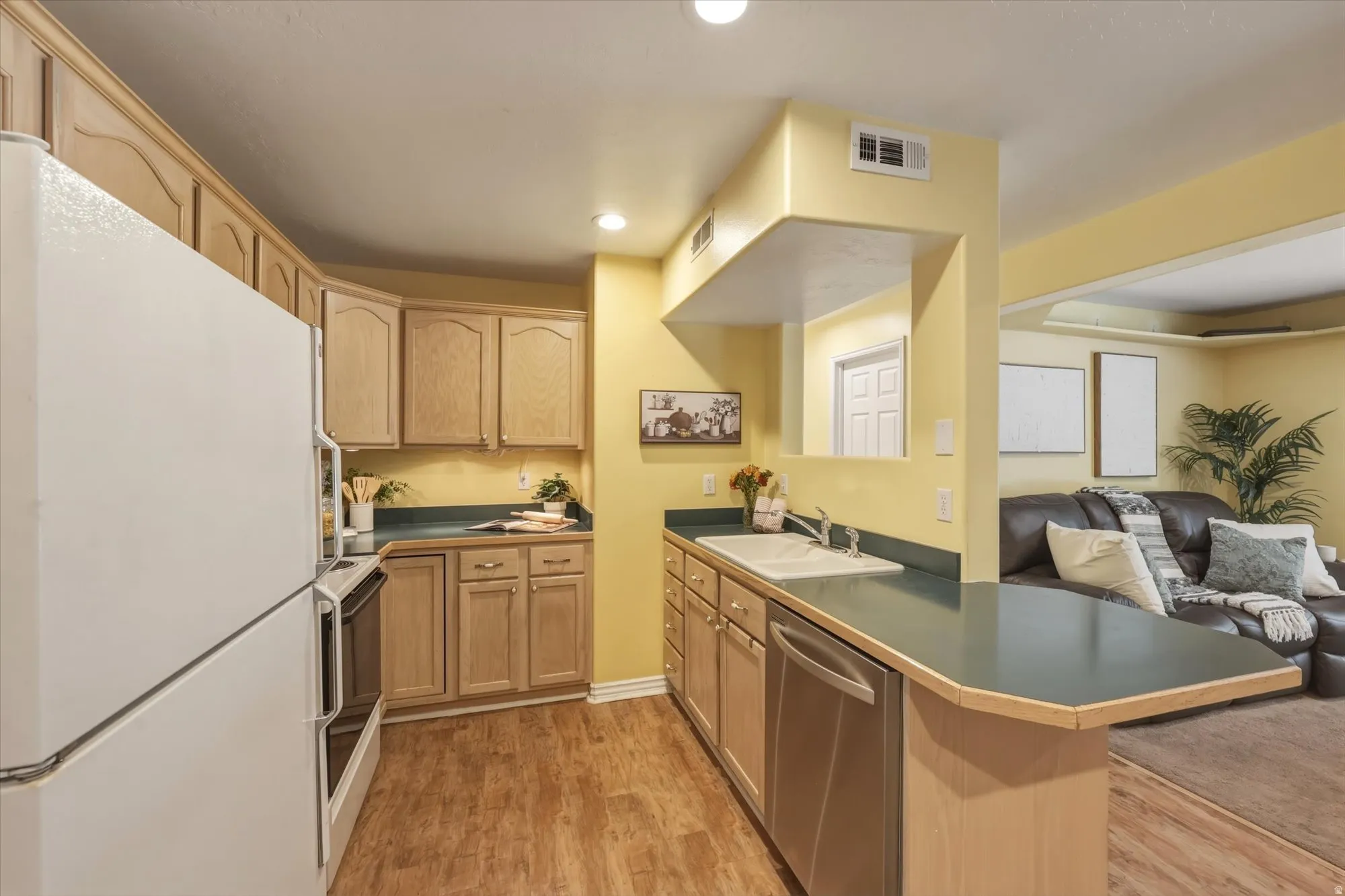 Kitchen featuring wood-finish flooring and light wood cabinetry