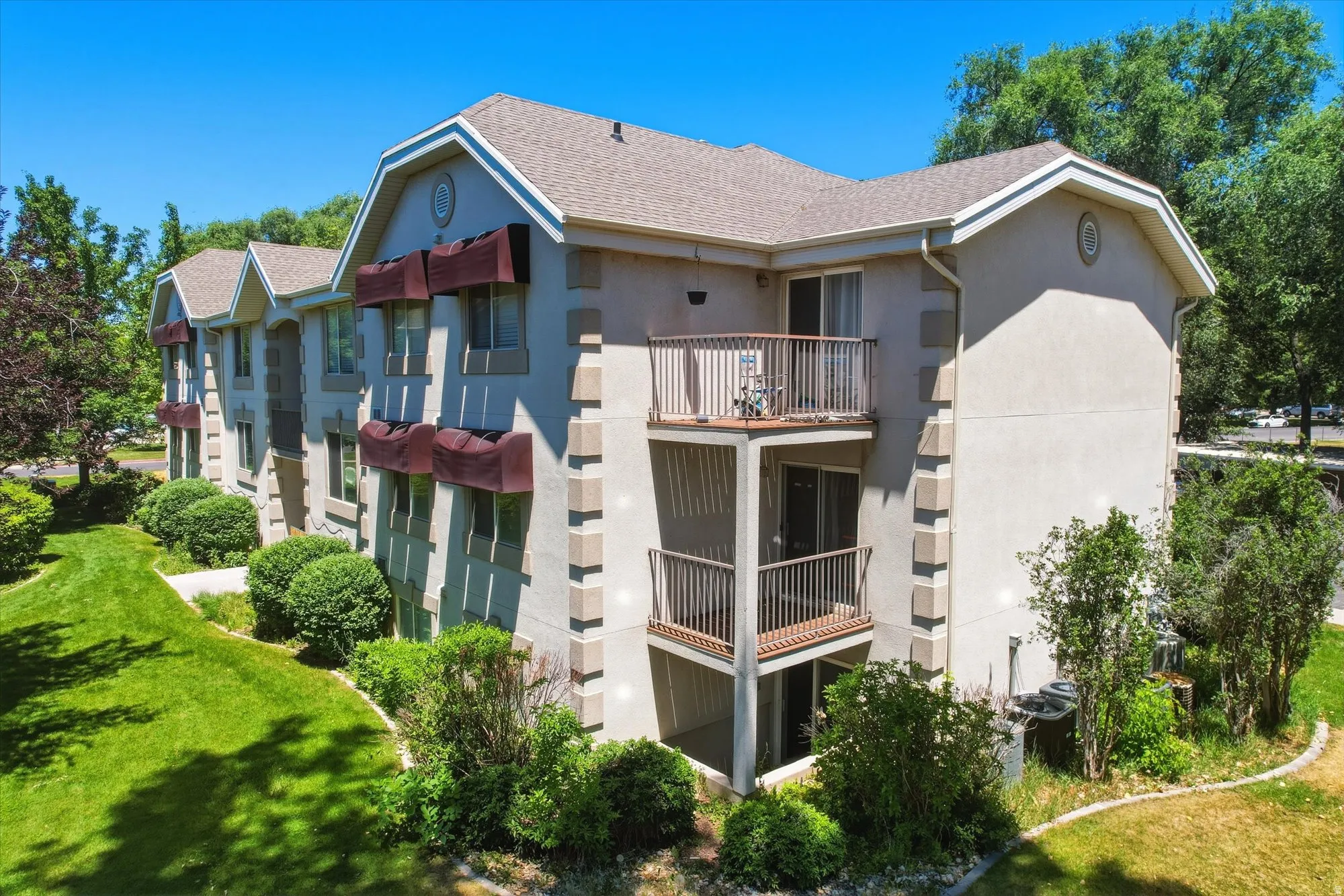 Multi-story building featuring stucco exterior, multiple balconies with metal railings, and decorative window awnings