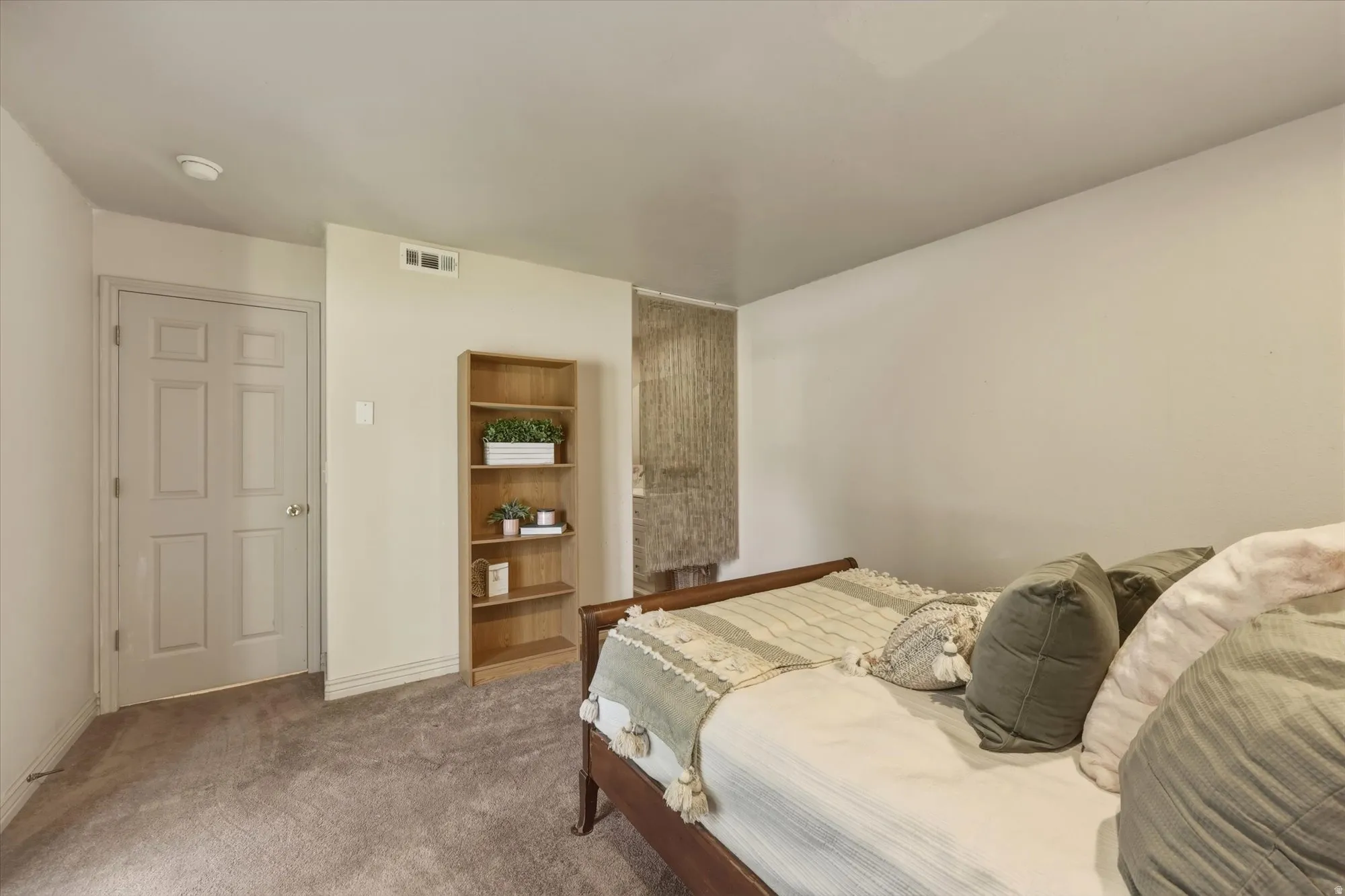 Neutral wall color, carpeted flooring, and a six-panel interior door