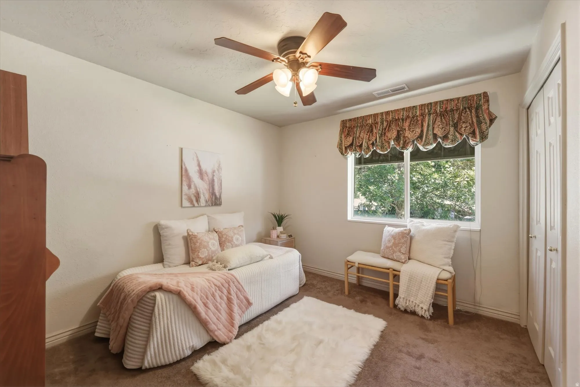 Well-lit interior space featuring neutral wall tones and brown carpet flooring