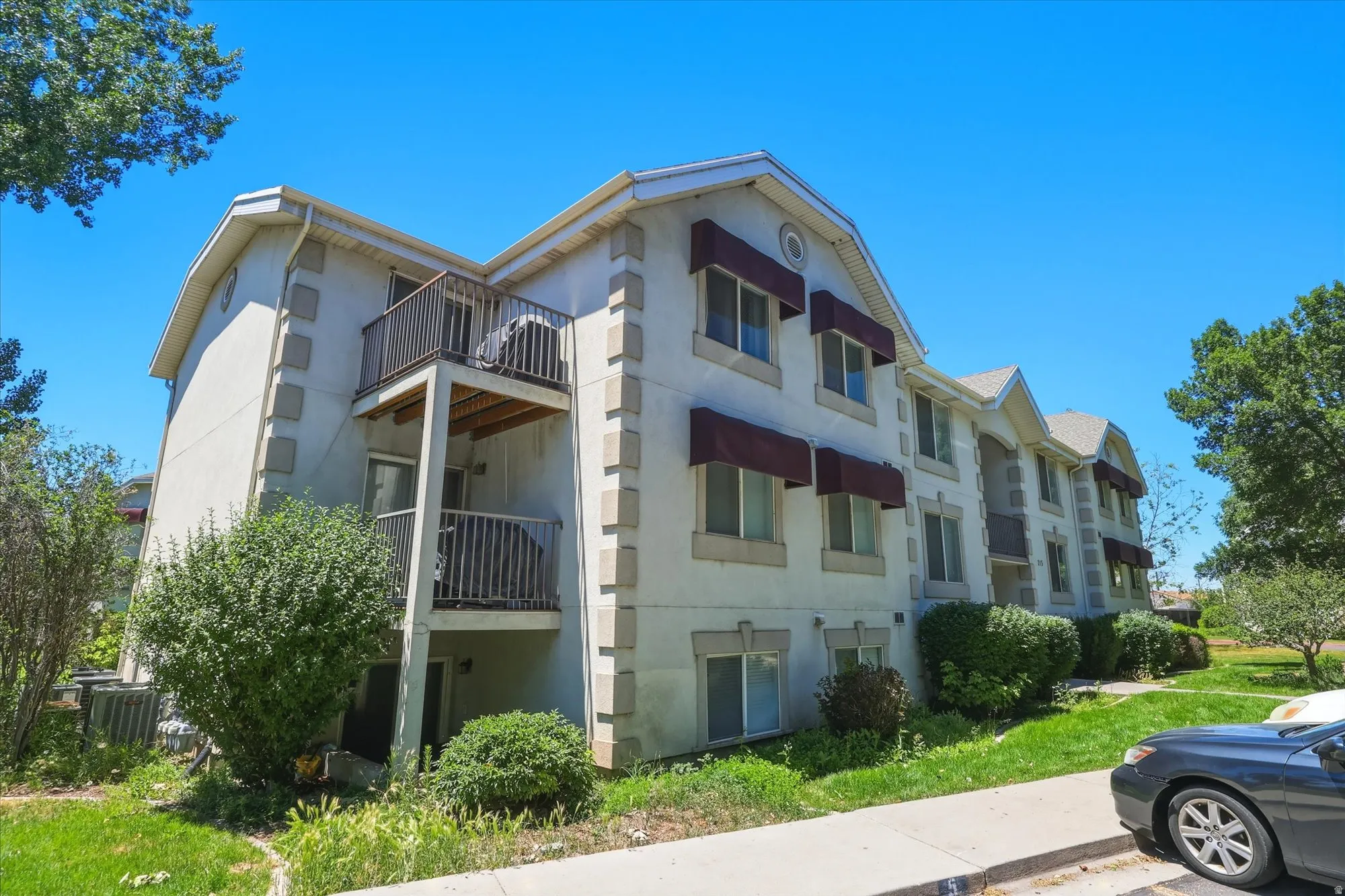 Three-story building with multiple balconies and window awnings