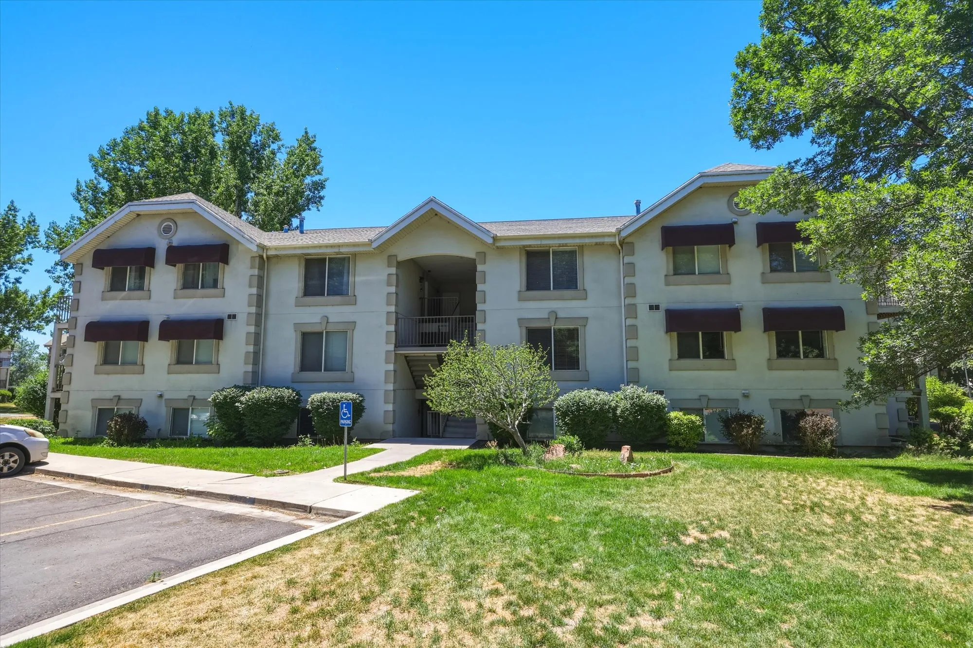 Multi-level residential building featuring a stucco exterior and accent stone trim