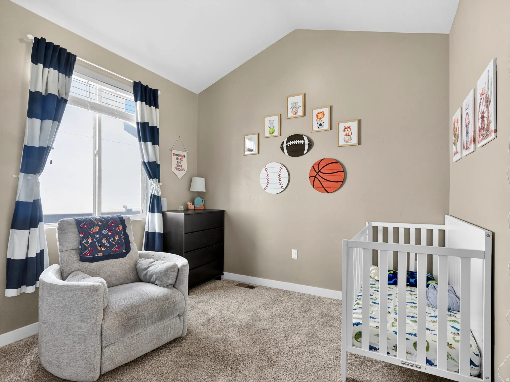 Vaulted ceiling room with neutral-toned walls and plush carpeting