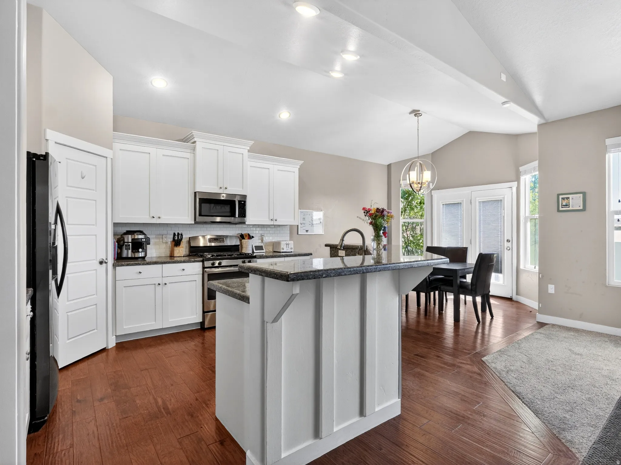 Bright kitchen featuring white cabinetry and stainless steel appliances