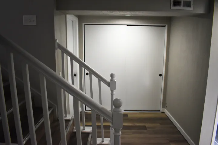 Hardwood-finish flooring extending from the staircase landing to a large closet with sliding doors
