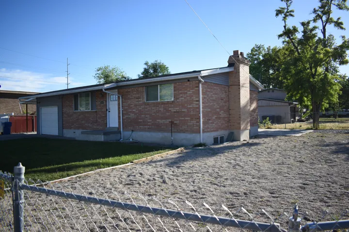 Brick exterior with a single-car garage and a white entry door