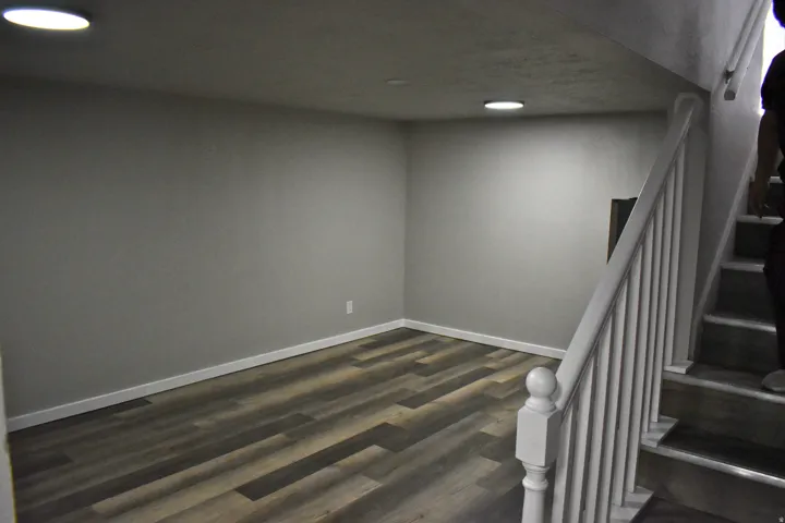 Open room featuring wood-finish flooring, recessed lighting, and white baseboards
