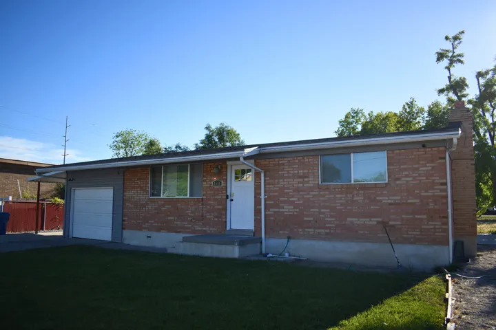 Brick and siding exterior residence featuring a single-car garage, white entry door, and a concrete front porch
