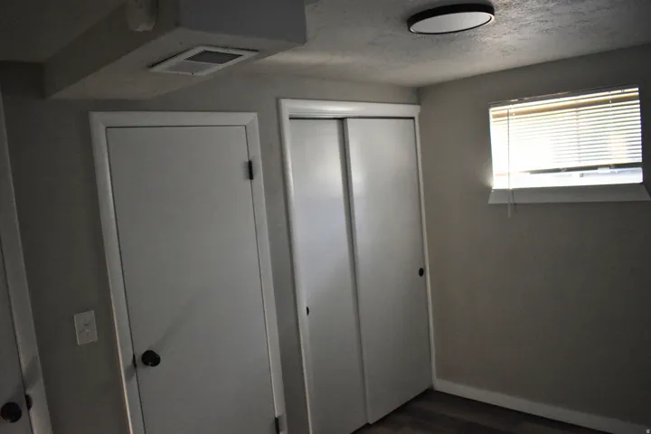 Room featuring light gray walls, wood-finish flooring, and a white ceiling