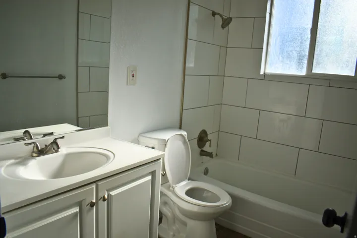 Bathroom featuring a white vanity with an integrated sink, brushed nickel faucet, and a large wall mirror