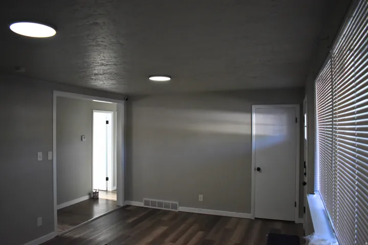 Interior room featuring wood-finish flooring, light gray wall paint, and white trim