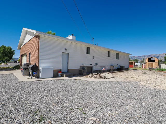 Side exterior with white horizontal siding and a red brick garage facade