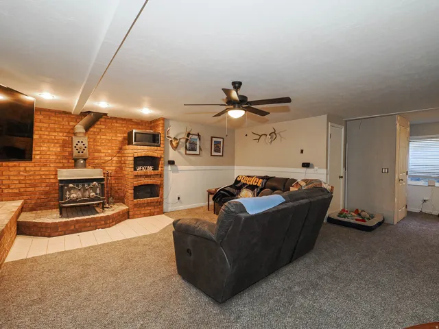 Living area featuring a brick accent wall with a wood-burning stove
