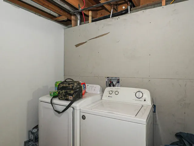 Unfinished utility area with exposed ceiling joists and visible plumbing lines