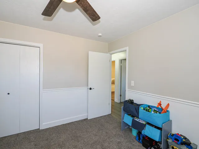 Neutral-toned walls with wainscoting and a textured carpeted floor
