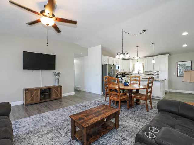Open-concept living space featuring wood-finish flooring, a contemporary ceiling fan, and recessed lighting