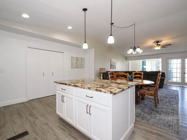 Kitchen island with a speckled countertop and white cabinetry