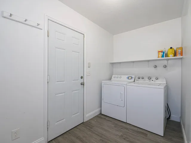 Dedicated laundry area featuring wood-finish flooring