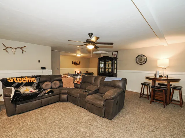Spacious interior with neutral carpeting and a ceiling fan