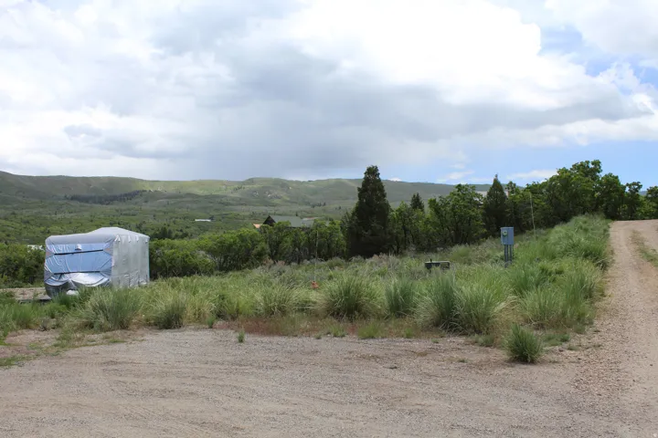 Gravel lot featuring natural landscaping and distant mountainous terrain