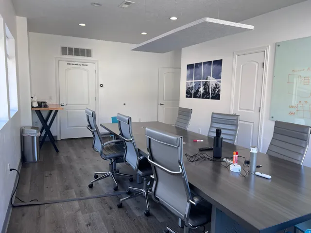 Conference room featuring wood-finish flooring, recessed lighting, and a suspended acoustic panel