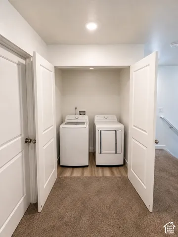 Dedicated laundry closet featuring a top-load washing machine and front-load dryer