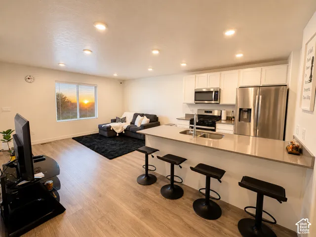 Open-concept living space with wood-finish flooring and recessed lighting