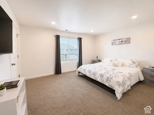 Spacious room featuring neutral carpeting and white walls