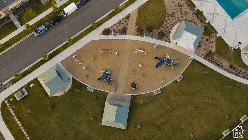 Community playground featuring multiple play structures, a sand base, and surrounding green spaces