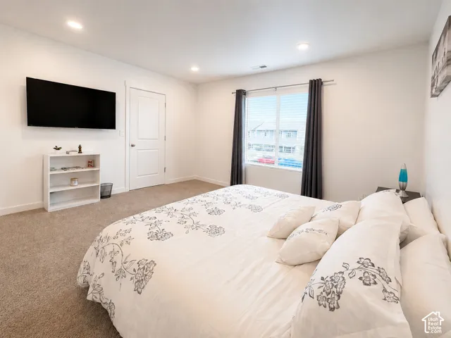 Carpeted room with recessed lighting and a window featuring horizontal blinds