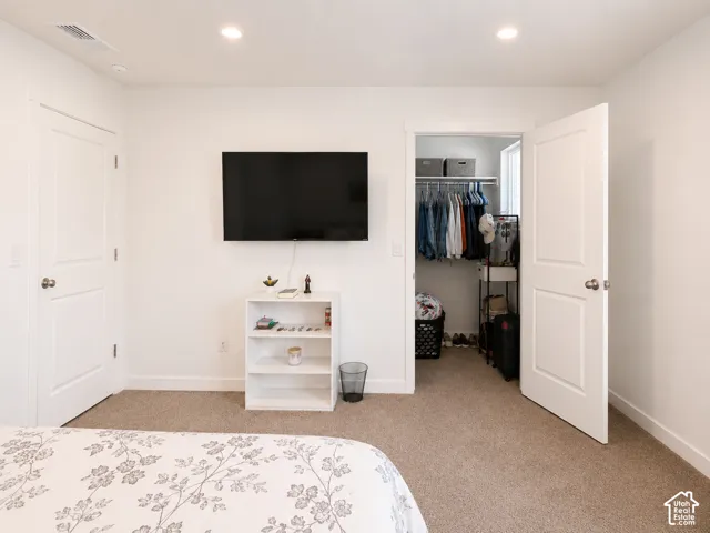 Neutral wall finishes, recessed lighting, and carpet flooring
