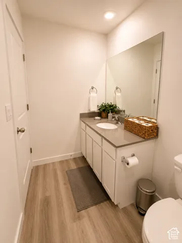 Powder room featuring a single vanity with shaker-style cabinetry, a built-in sink, and a large wall-mounted mirror