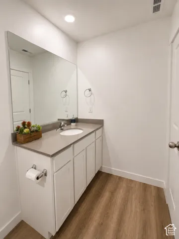 Bathroom vanity featuring a light gray countertop, undermount sink, and chrome faucet