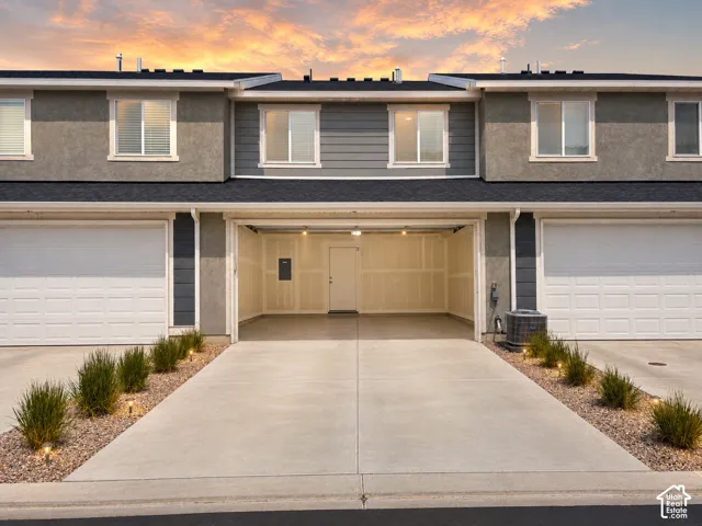 Two-car attached garage with concrete driveway and overhead lighting
