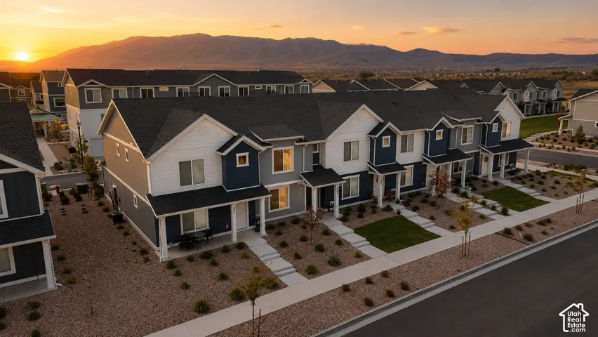 Modern townhome community featuring varied siding colors, white trim, and dark shingle roofs
