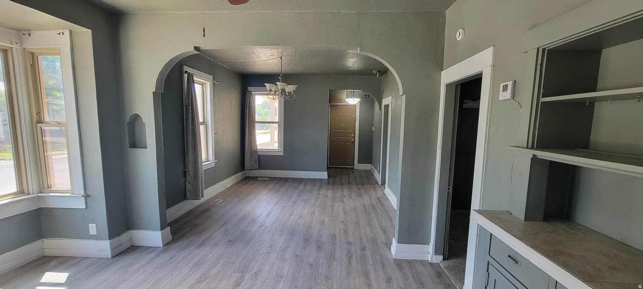 Spacious interior featuring light wood-finish flooring and arched doorways