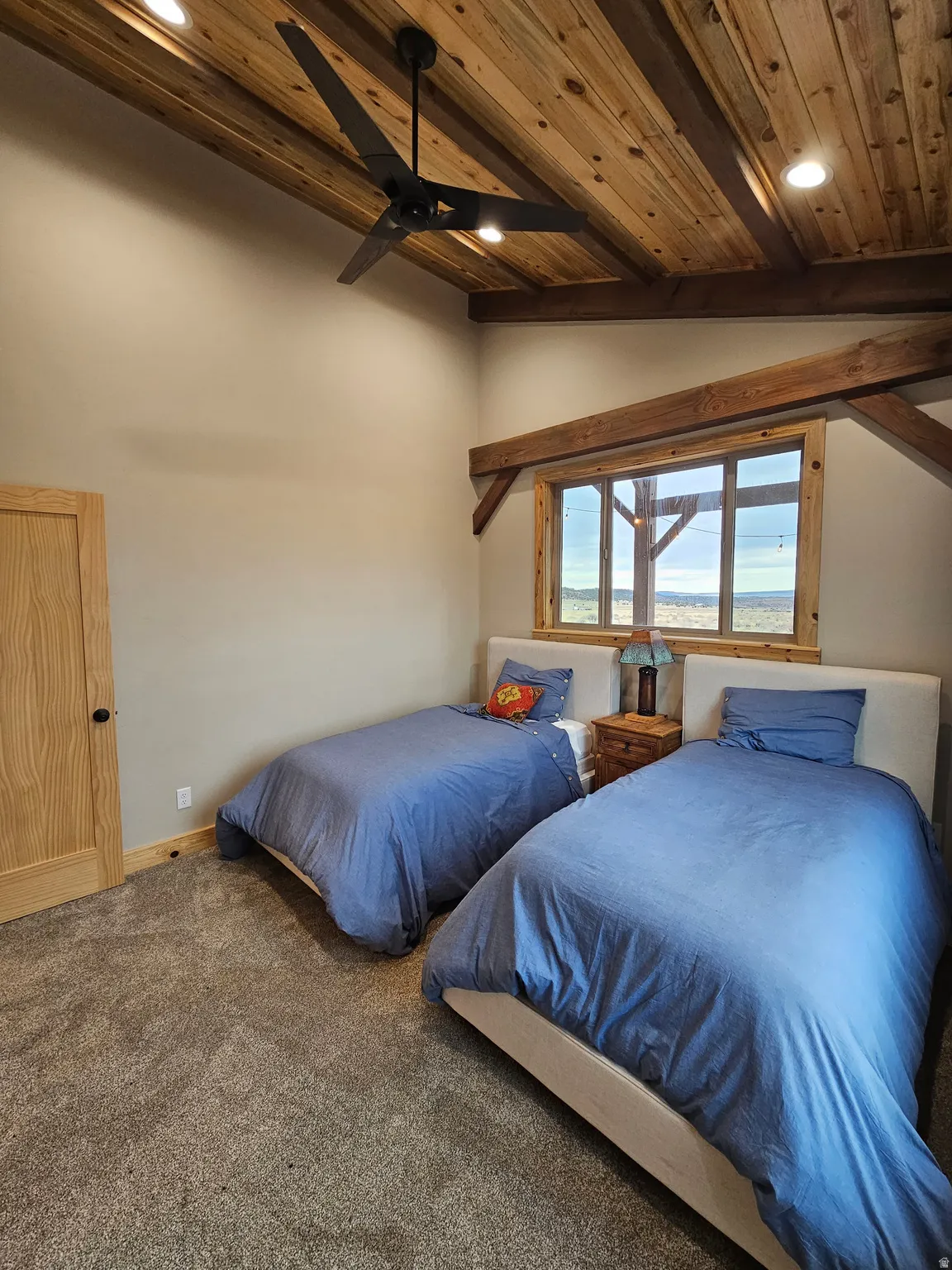 Bedroom with vaulted wood ceiling with exposed wood beams