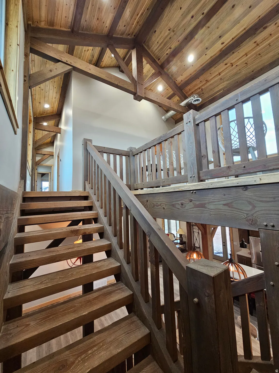 Expansive wood-finish staircase featuring a matching railing system