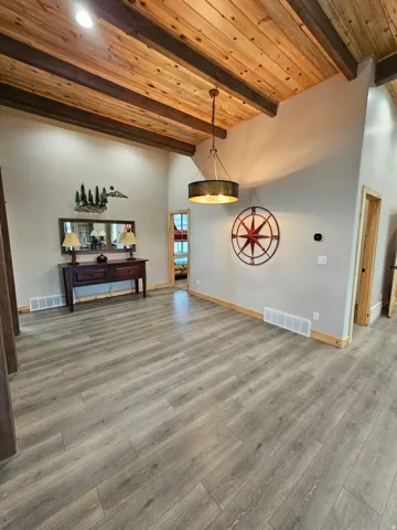 Vaulted ceiling featuring exposed wood beams and planking