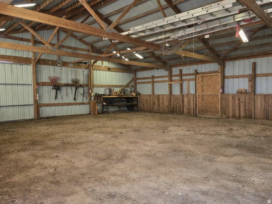 Spacious interior with exposed wood beam trusses and a corrugated metal roof