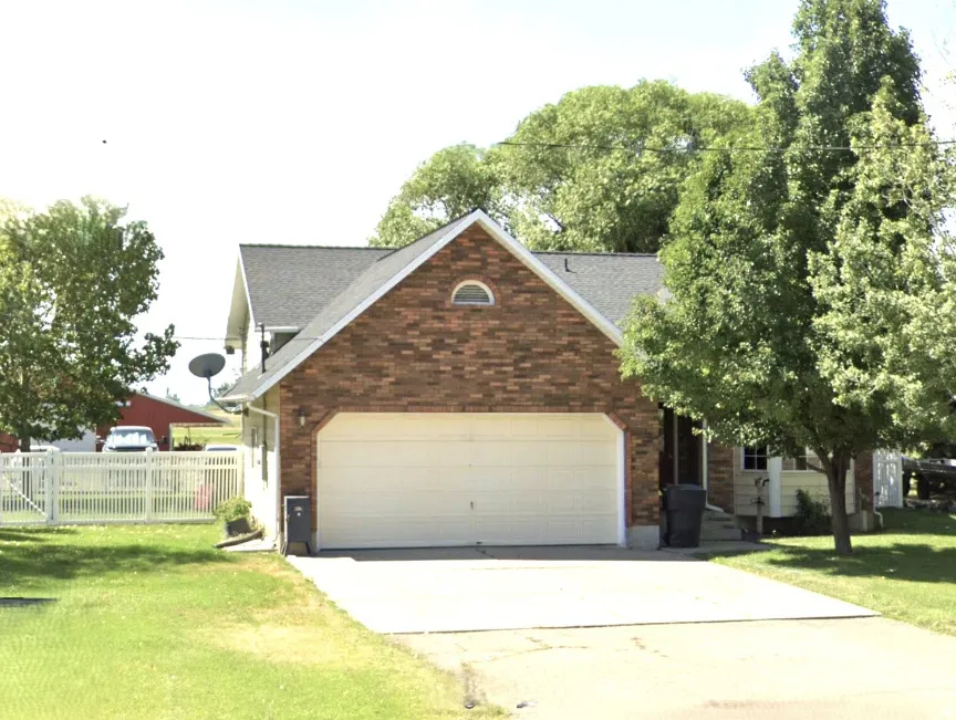 Brick exterior with an attached two-car garage, featuring a white garage door