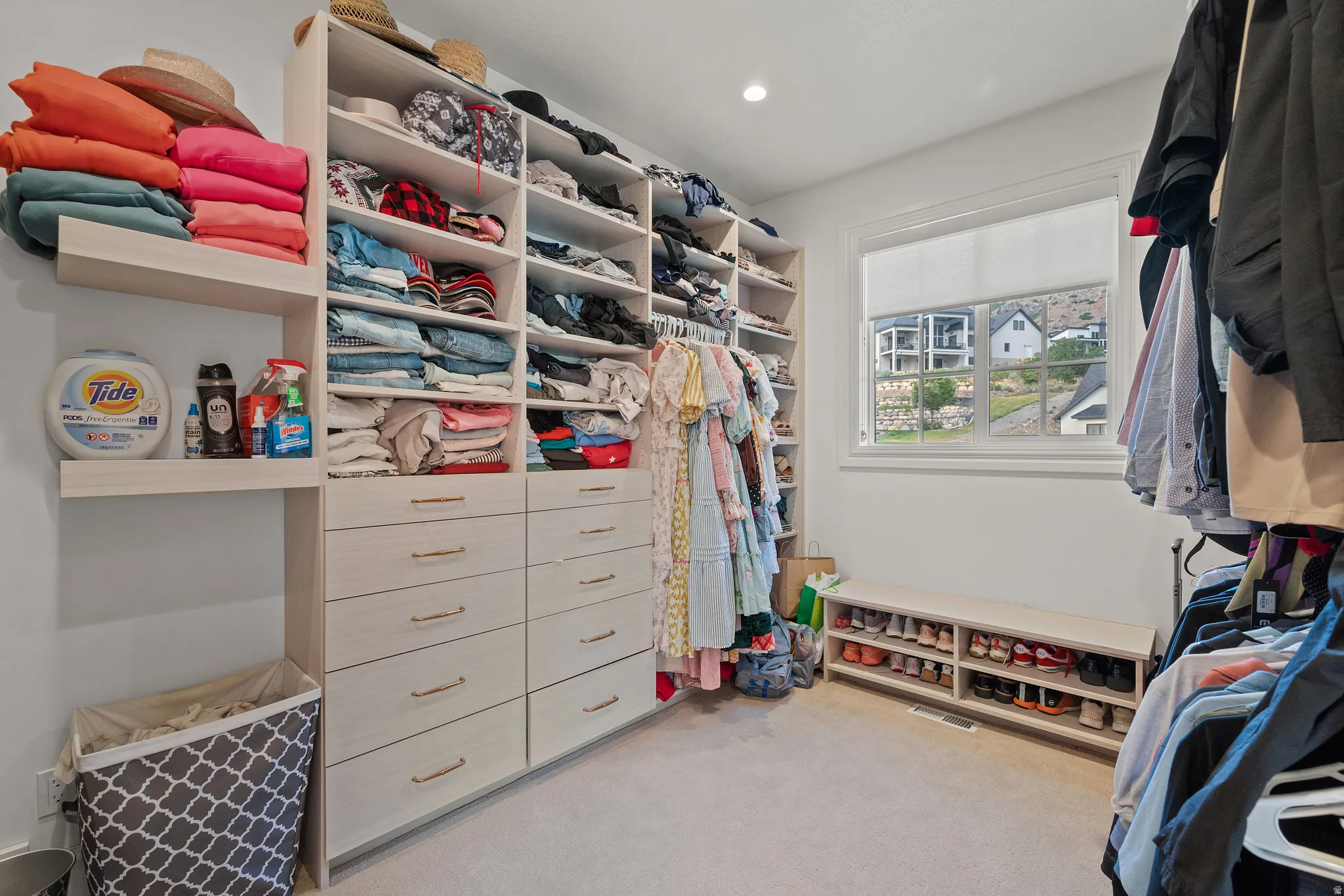 Custom built-in storage solutions featuring shelving, drawers with modern hardware, and hanging rods