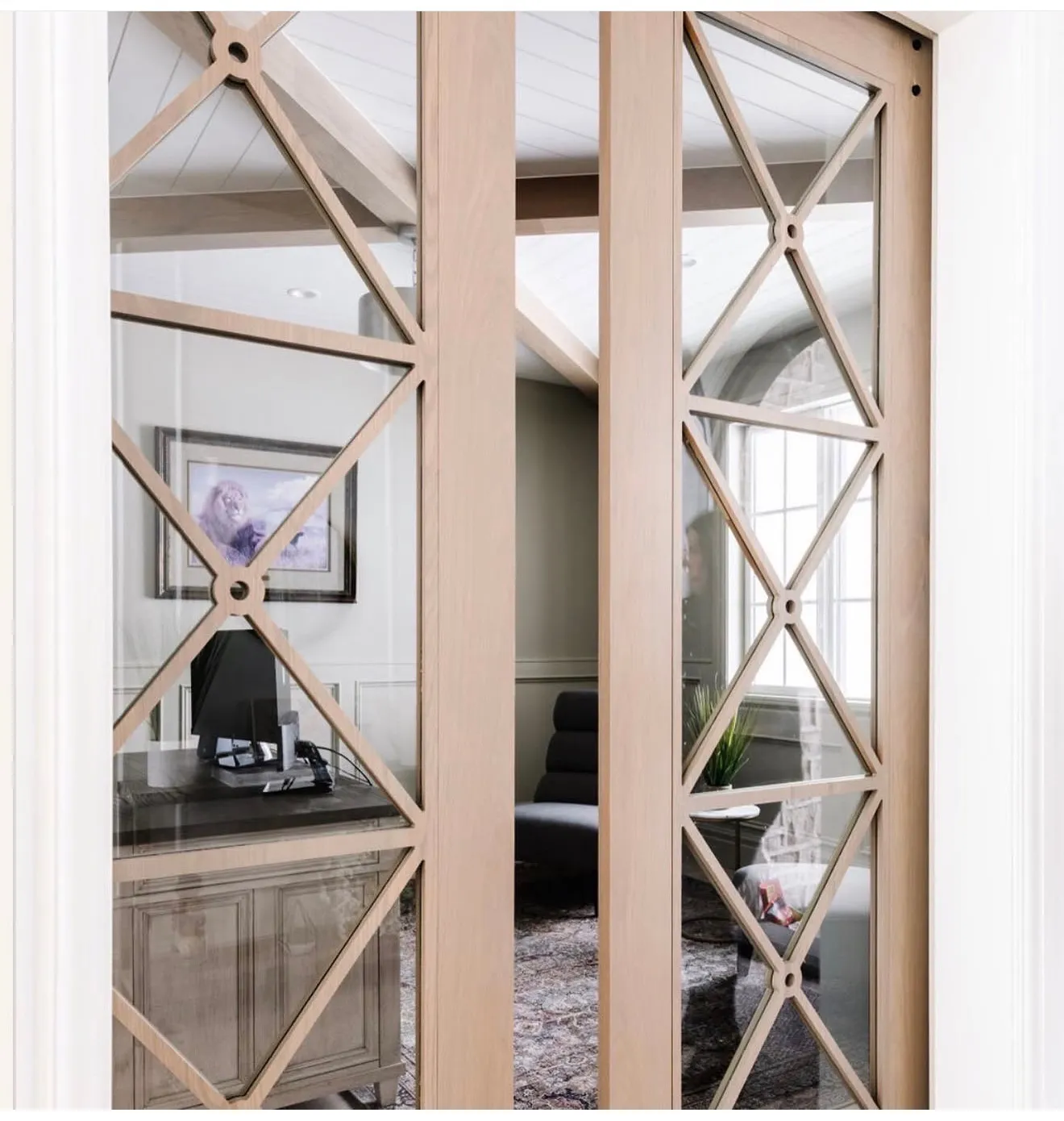 Custom wood-frame pocket doors with geometric grilles and clear glass panels